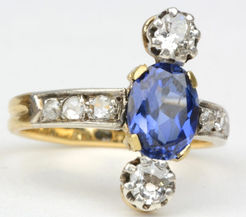 Een 18 karaats geel gouden ring bezet met diamanten met een gezamenlijk gewicht van ± 0,50 ct. en een centrale saffier van ± 1 ct.