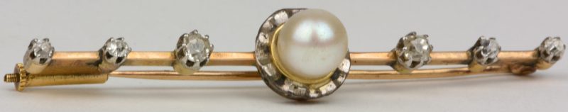 Een 18 karaats geel gouden broche bezet met diamanten met een gezamenlijk gewicht van ± 0,20 ct. en een parel.