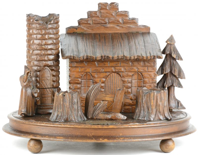 Een bureaustel van gesculpteerd hout in de vorm van een tovenaar bij een hutje met inktpotten in de vorm van boomstronken.