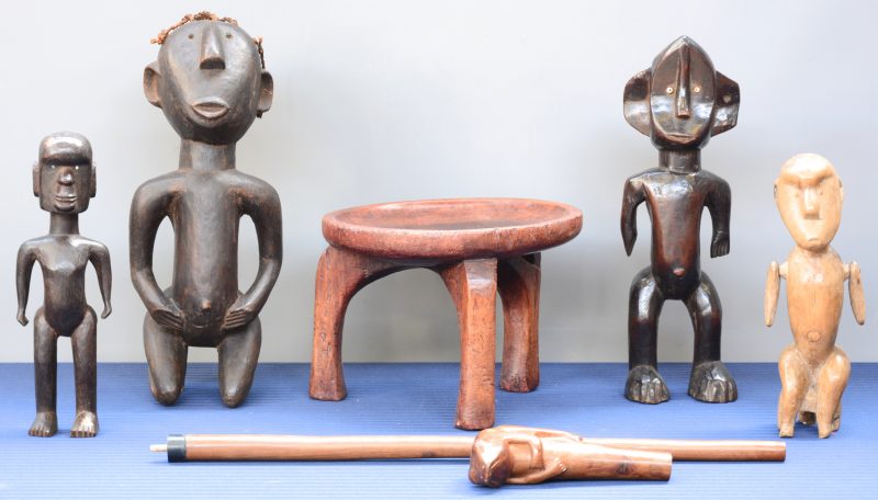 Een lot bestaande uit vier gebeeldhouwde houten beeldjes van de Paré. Evenals een sokkeltje en een scepter van de Yoruba.