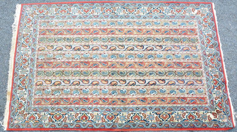 Een handgeknoopt Perzisch karpet van wol en katoen.