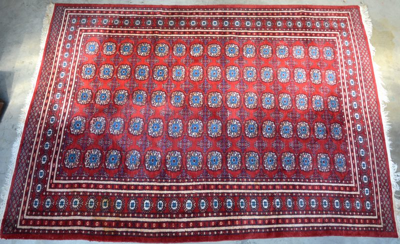 Een Oosters tapijt met een veelkleurig Gül-motief. Handgeknoopt.