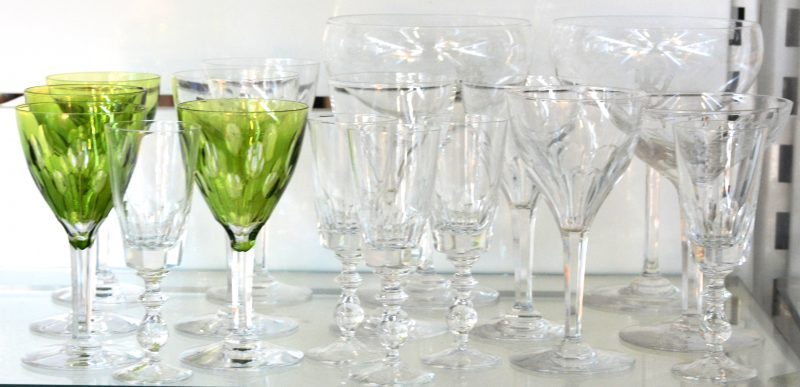 Een lot kristallen glazen, waarbij vier groene en vijf kleurloze wijnglazen, vijf kleine champagnefluiten, twee grote en een kleine champagnecoupe.