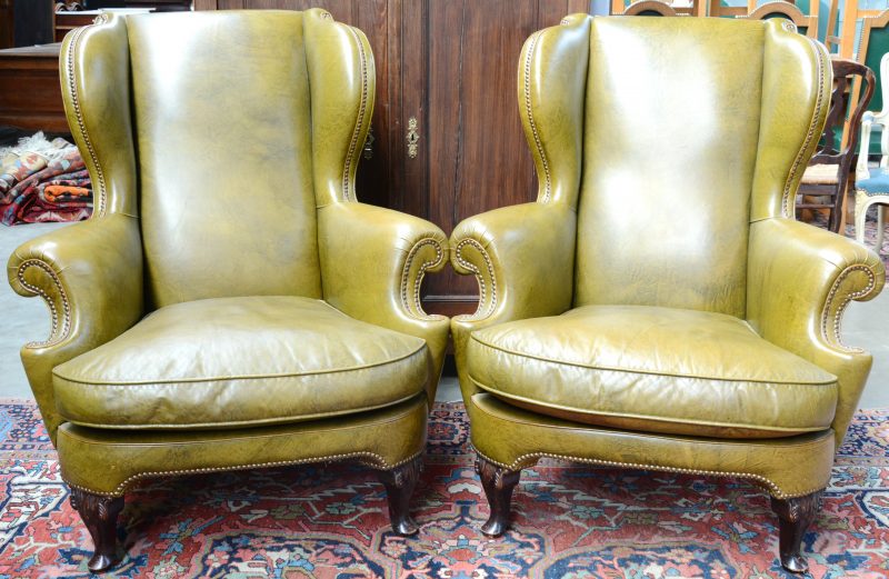 Een paar wingchairs met groen kunstlederen bekleding.