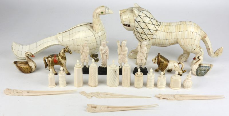 Een lot ivoor en been, bestaande uit parfumflesjes, haarspelden, Chinese figuurtjes, grote en kleine diertjes.