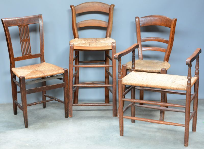 Een lot meubelen, bestaande uit een bankje, twee stoeltjes en een hoge stoel met rieten bekleding.
