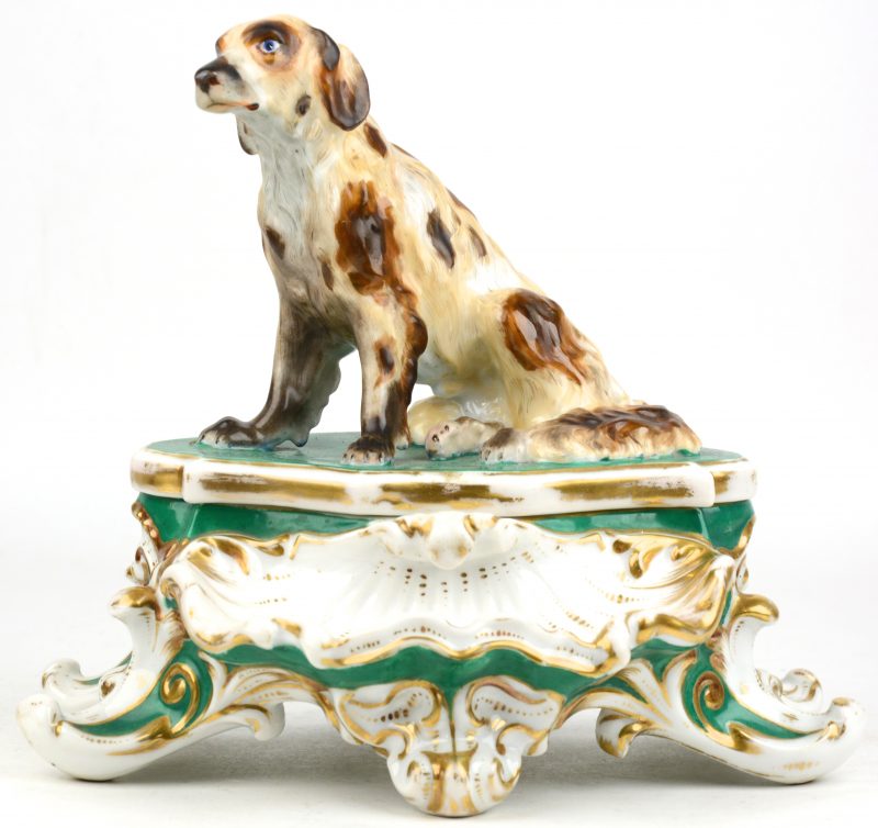 Een inktstel van meerkleurig en verguld Brussels porselein, getooid met een hond op het deksel. Recipiënten incluis. Eind XIXe eeuw.
