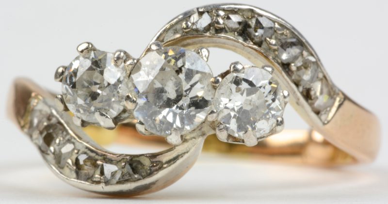Een 18 karaats wit en geel gouden ring bezet met diamanten oude slijp en briljanten met een gezamenlijk gewicht van ± 1 ct.