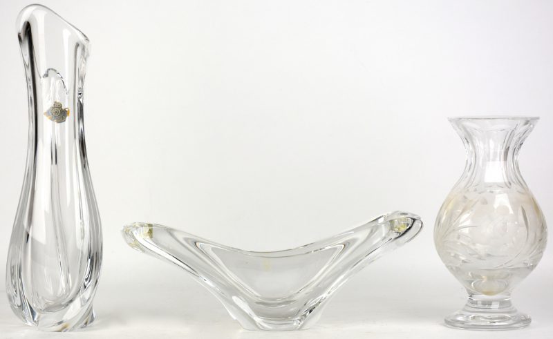 Een lot kleurloos kristal, bestaande uit een vaas van Val St. Lambert, een dubbele kandelaar en een vaas op voet met een geslepen bloemendecor.