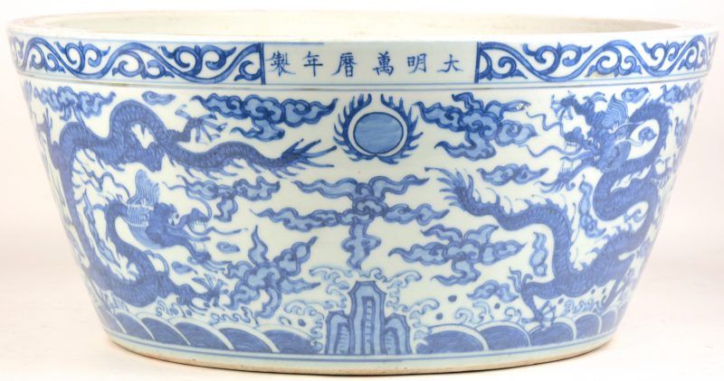 Een grote schaal van Chinees porselein met een blauw en wit drakendecor.