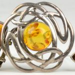 Een armband, twee broches en een paar oorbellen van amber gezet in zilver van 925 ‰.