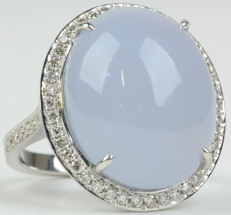 Een 18 karaats wit gouden ring bezet met diamanten met een gezamenlijk gewicht van ± 0,65 ct. en een calcedoon van ± 18,72 ct.