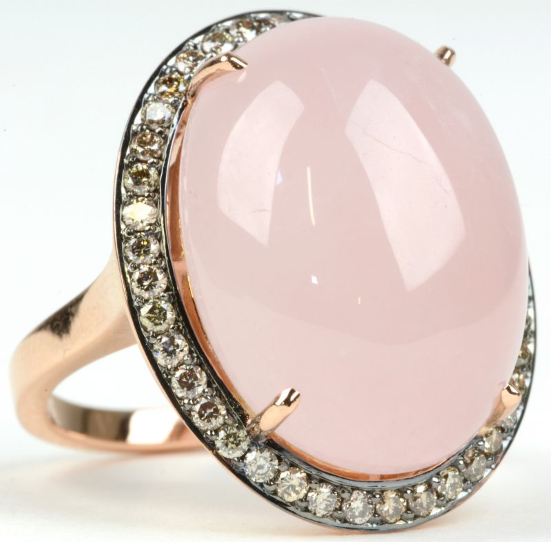 Een 18 karaats wit gouden ring bezet met diamanten met een gezamenlijk gewicht van ± 0,52 ct. en roze calcedoon van ± 16,67 ct.