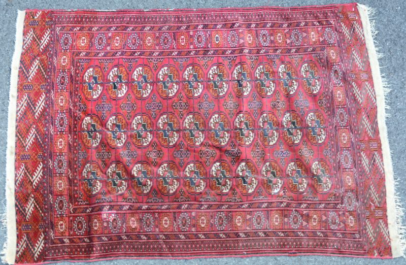 Karpet van wol met een Yomoud-motief op rode fond. Handgeknoopt.
