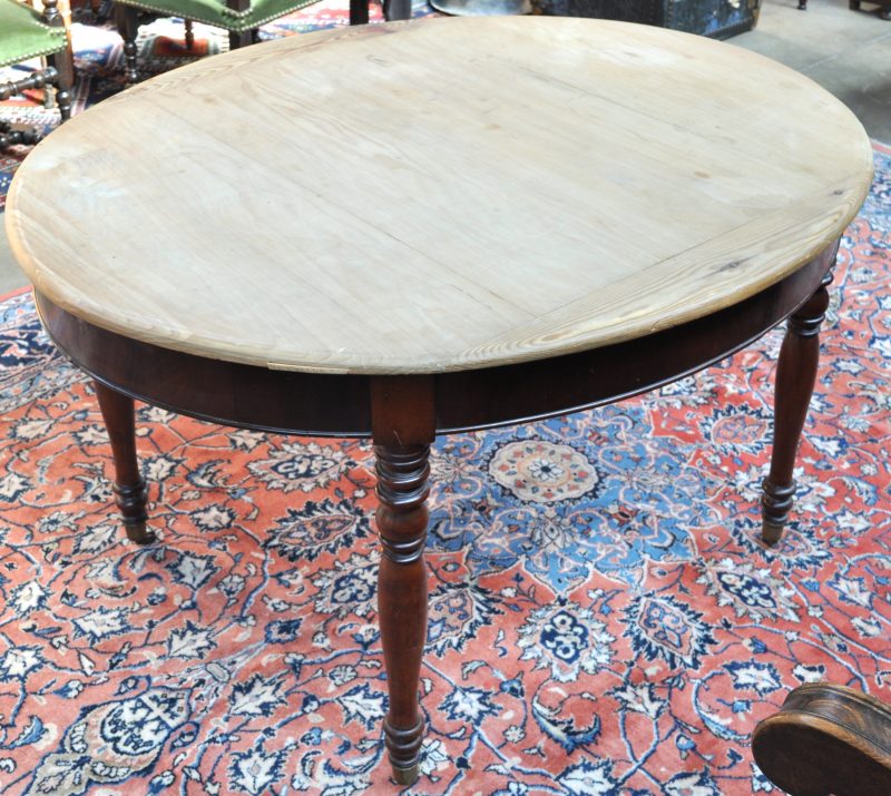 Een ovale tafel van mahoniehout op vier gedraaide poten met vernauwingen en op messingen wieltjes Tijdperk Louis-Philippe. Tafelblad vervangen door grenenhout.