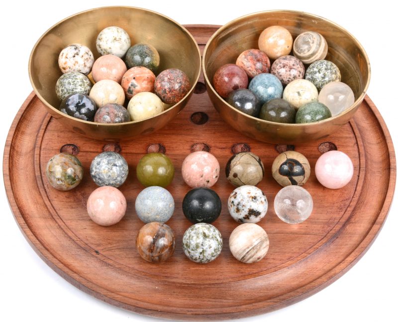 Een rond bordspel met 38 bollen van verschillende mineralen