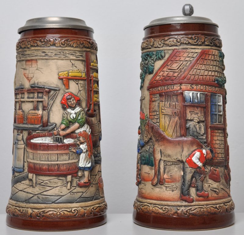 Twee bierpullen van aardewerk met tinnen deksels. De éne met een wasvrouw en haar dochter (H. 24 cm), de andere met een paardensmid (H. 25 cm). Beide onderaan gemerkt ZB, voor Zöller & Born.