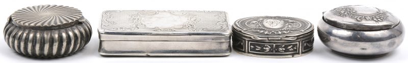 Twee zilveren pillendoosjes, waarvan één met Duitse keuren. We voegen er twee verzilverde exemplaren aan toe, waarbij één gemerkt van Wiskemann. Gewicht zilver: 73g.