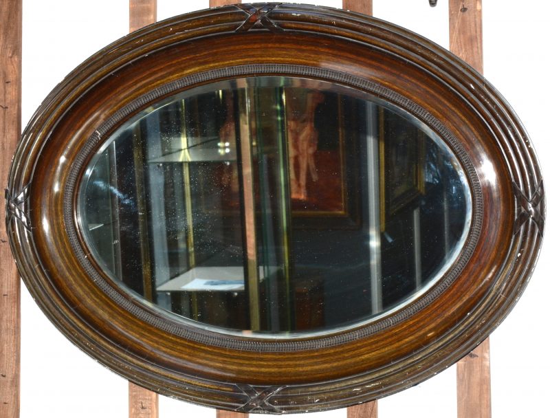 Een ovale spiegel in Lodewijk XVI-stijl.