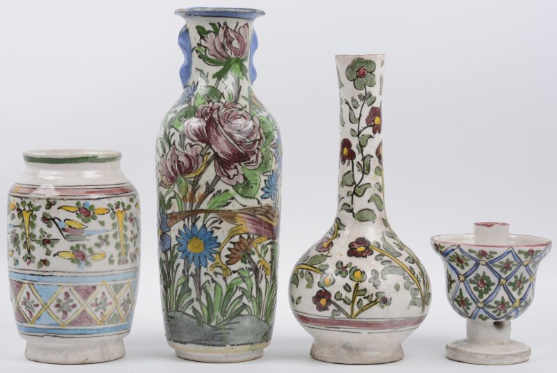 Een lot meerkleurig Perzisch aardewerk, bestaande uit een drie verschillende vazen en een kaarsenhouder.