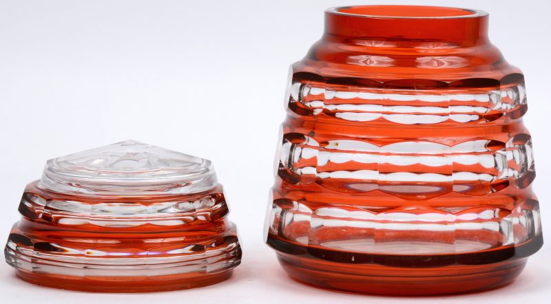 Een vaas en een bonbonnière van geslepen kristal, oranje gekleurd in de massa.