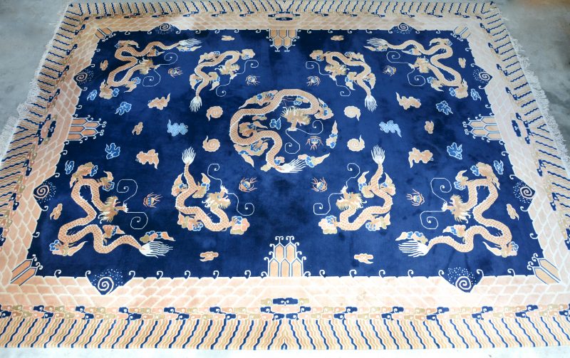 Een handgeknoopt Chinees wollen tapijt met draken in het decor.