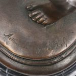 “De slangenbezweerder”. Een beeld van bruingepatineerd brons op zwart marmeren voetstuk. Naar een werk van Charles Arthur Bourgeois.
