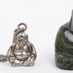 Een lot diverse juwelen, bestaande uit een snoer van avonturiet en één van tijgerooog, een zilveren ring met amber en één met groen jade, een kleine zilveren Boeddha als hanger en één van jade en een kleine bronzen hanger als souvenir uit 1959.