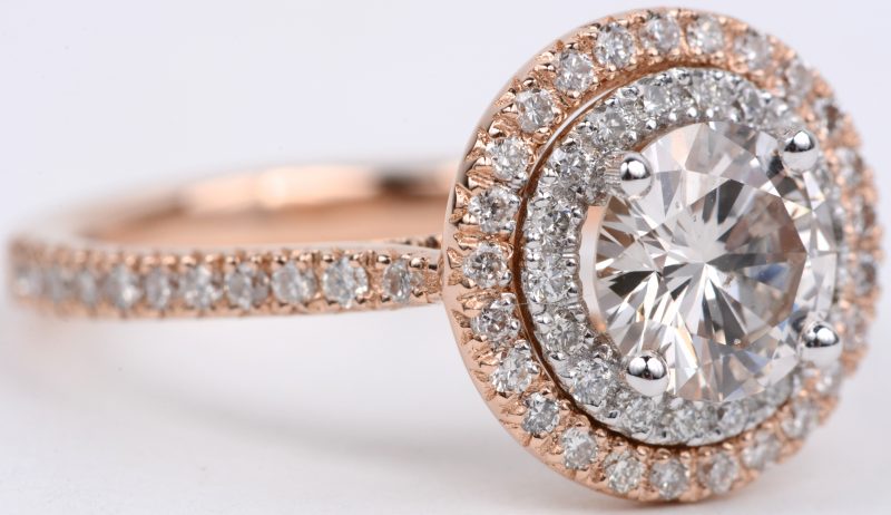 Een 18 karaats wit en roze ring bezet met diamanten met een gezamenlijk gewicht van ± 0,52 ct. en een centrale diamant van ± 1,04 ct.