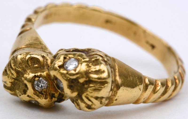 Een 18 karaats geel gouden ring in de vorm van leeuwenkopjes bezet met vier briljantjes.