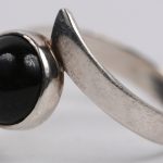 Een ketting met hanger en bijpassende ring bezet met obsidiaan en van 925 ‰ zilver.