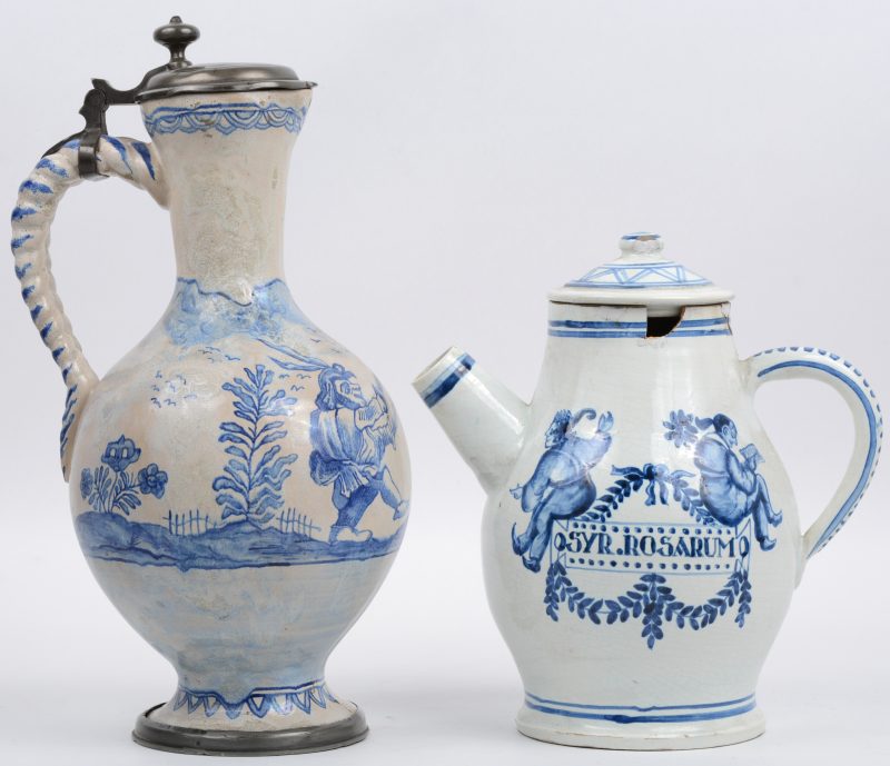 Een klepkan en een theepot van blauw en wit aardewerk, de eerste versierd met zittende figuren, de tweede met zwaardvechters en met tinnen monturen. De eerste beschadigd aan de rand.