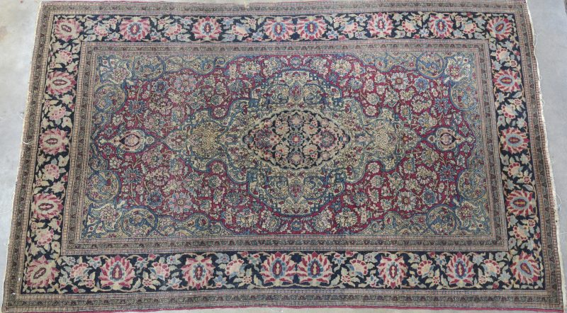 Een handgeknoopt Perzisch karpet van wol met een centraal medaillon in het decor.