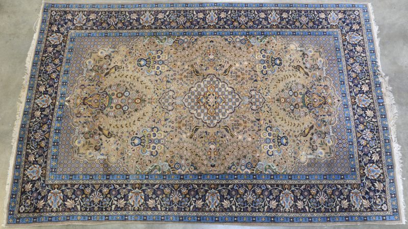 Een fijn geknoopt Perzisch tapijt van wol en katoen. Lichte slijtage aan de rand.