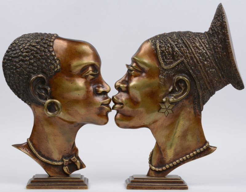 Een paar Afrikaanse hoofden in profiel van gepatineerd brons op staander.