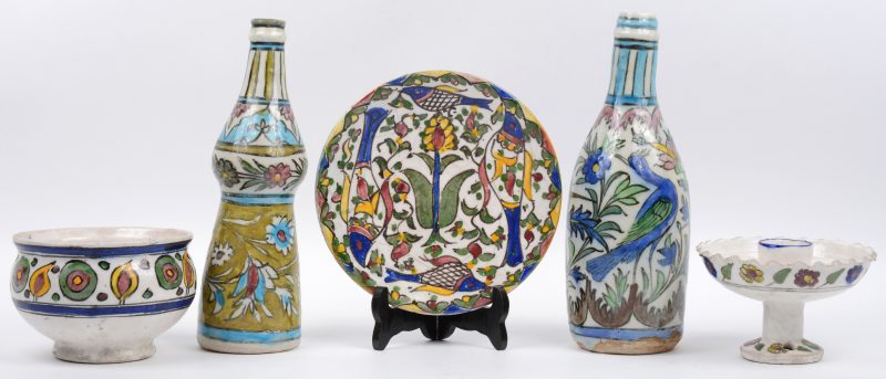 Een lot van vijf stuks meerkleurig Perzisch aardewerk, bestaande uit een schaaltje, een kom, een kandelaar en twee flessen. Izmir.