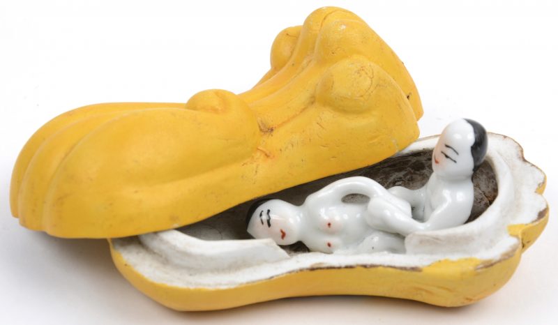 Een dekseldoosje van geelgepatineerd biscuit met binnenin en porseleine erotische voorstelling. Chinees werk.