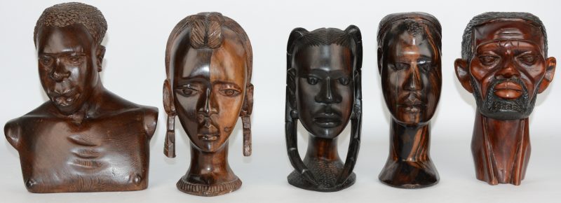 Een lot van vijf Afrikaanse hoofden van gesculpteerd hout.