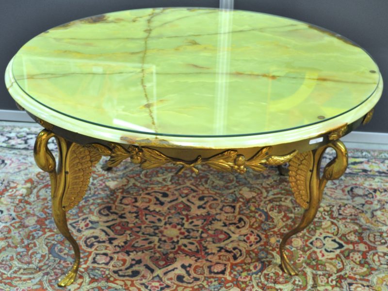 Een salontafel van geel koper met een onyxen blad. Poten in de vorm van zwanen.
