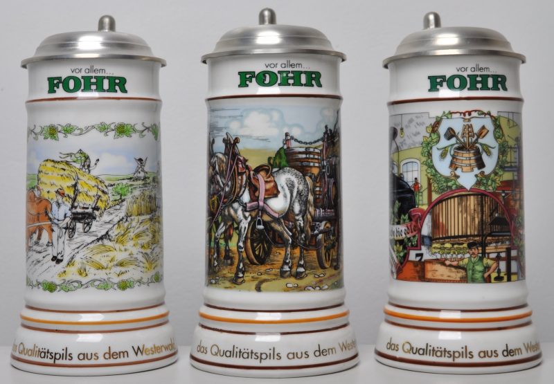 Drie bierpullen van porselein met tinnen deksels voor “Fohr, das Qualitätspils aus dem Westerwald” H. 22 cm.