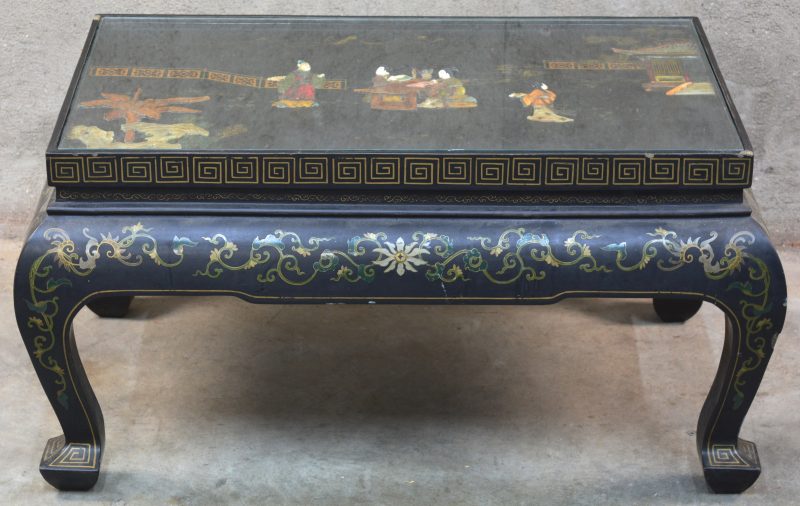Een Chinese salontafel van zwartgelakt hout met een decor van personages van pietra dura in het blad.