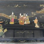Een Chinese salontafel van zwartgelakt hout met een decor van personages van pietra dura in het blad.