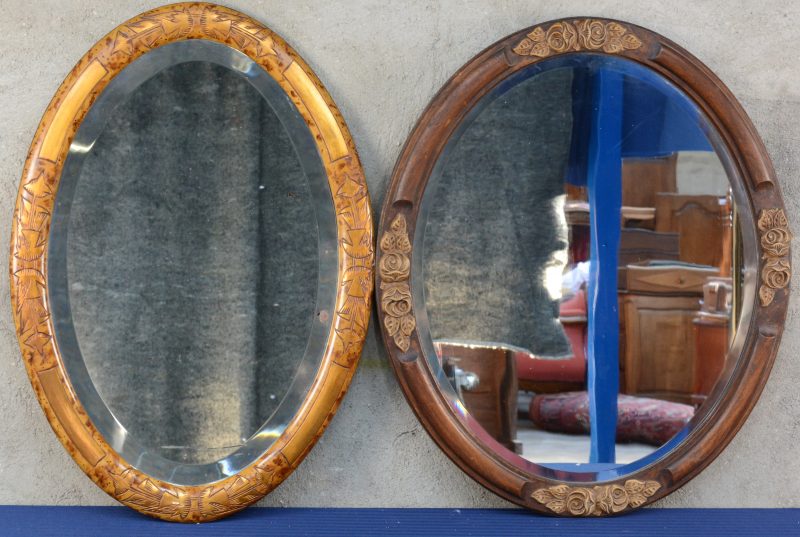 Twee verschillende ovale wandspiegels van gebeeldhouwd hout.