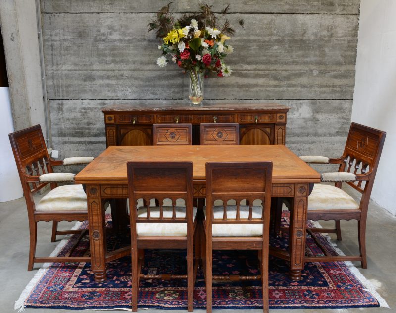 Een eetkamer in eclectische stijl, bestaande uit een lange buffetkast met vier paneeldeuren, drie laden en een marmeren blad, een verlengbare tafel, twee armstoelen en vier stoelen. Begin XXste eeuw.