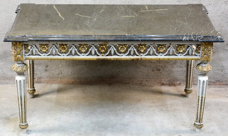Een salontafel van witgepatineerd en verguld hout in Lodewijk XVI-stijl met een zwart marmeren blad.