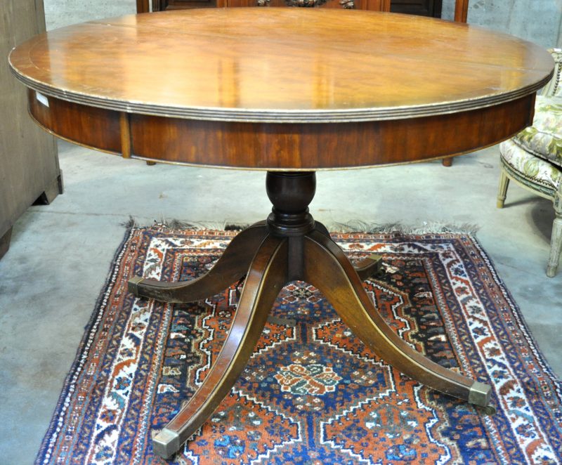 Een verlengbare ronde tafel van mahoniehout in Regencystijl. Met twee verlengbladen.