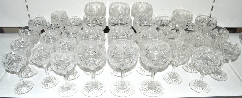 Een gedeeltelijk glasservies van geslepen kleurloos kristal, bestaande uit twaalf waterglazen, twaalf wijnglazen en negen champagnecoupes.