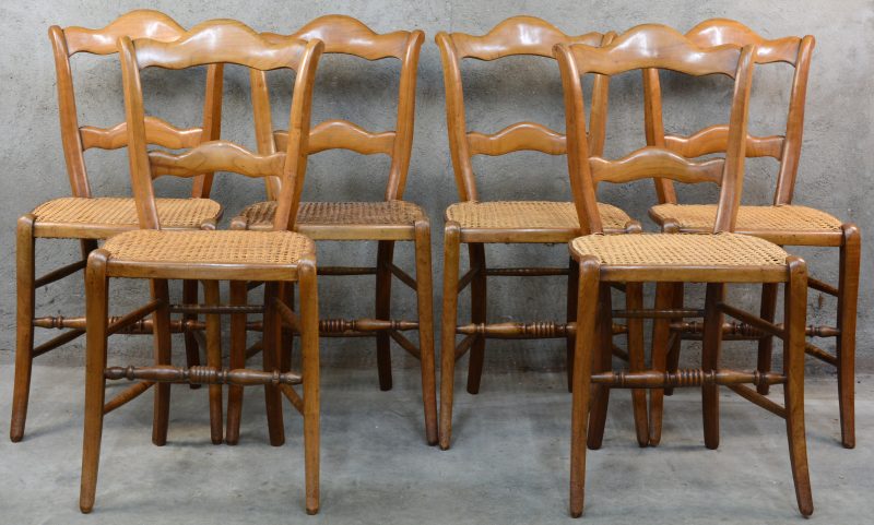 Een serie van zes eikenhouten stoelen met gecanneerde zit.