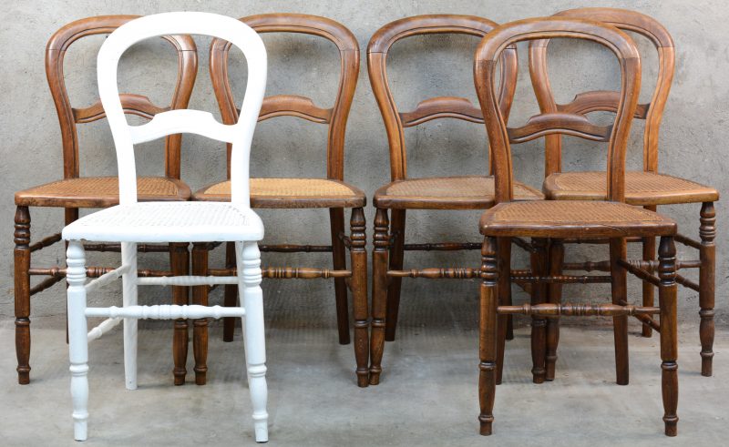 Een serie van zes gesculpteerde stoelen met gecanneerde zit, waarbij één witgepatineerd.