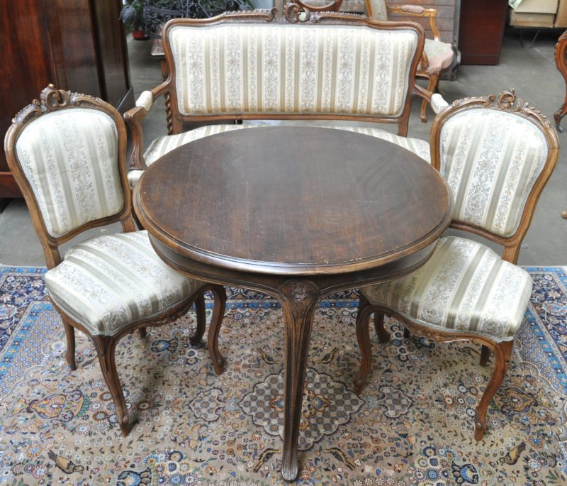 Een salon in Lodewijk XV-stijl bestaande uit twee stoelen, een canapé en een ronde tafel.